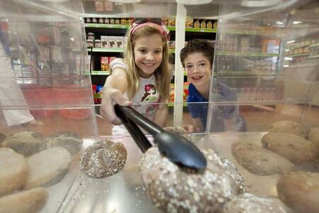 Kinderen kopen broodjes in de supermarkt op vakantiepark Roompot Buitenhof Domburg