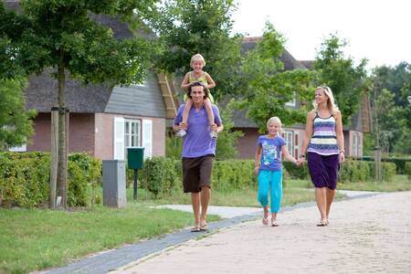 Familienspaziergang vor den Ferienhäusern im Ferienpark Roompot Buitenplaats De Hildenberg