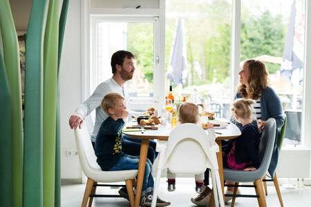 Familie beim Abendessen im Restaurant des Roompot Bungalowpark Hoenderloo