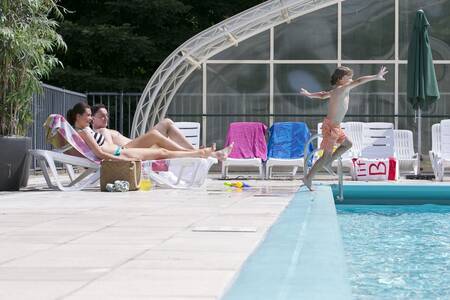 Menschen im Schwimmbad mit ausfahrbarem Dach im Roompot Bungalowpark Hoenderloo