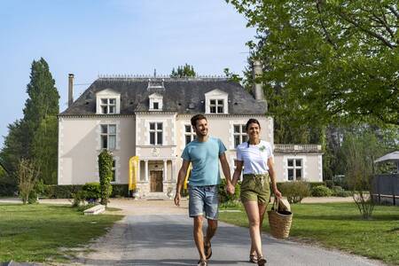 Ein Paar geht durch den Ferienpark Roompot Château des Marais