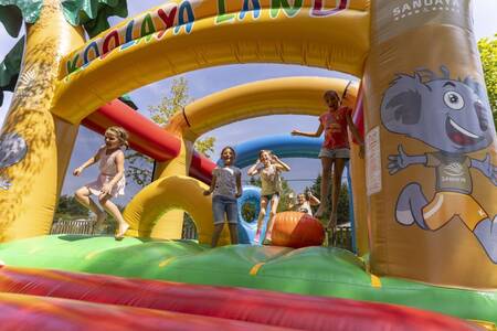 Kinder springen auf der Hüpfburg im Ferienpark Roompot Côte de Nacre