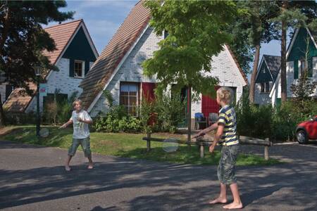 2 Kinder spielen Badminton zwischen den Ferienhäusern im Ferienpark Roompot De Katjeskelder