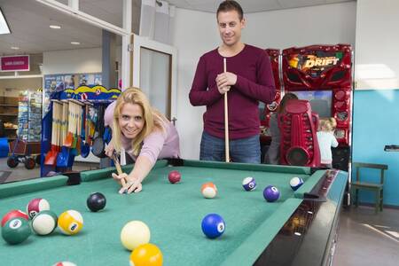 Mann und Frau spielen Billard im Ferienpark Roompot De Soeten Haert