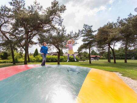 2 Kinder springen auf dem Lufttrampolin auf dem Spielplatz von Roompot De Veluwse Hoevegaerde
