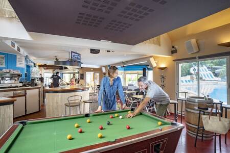 Ein Paar spielt Billard im Ferienpark Roompot Deux Fontaines