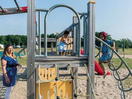 Kinder spielen auf dem Spielplatz im Ferienpark Roompot Duinresort Dunimar