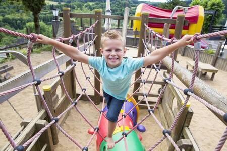 Kind spielt auf einem Spielplatz im Ferienpark Roompot Eifelpark Kronenburger See