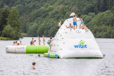 Kinder spielen auf einem Spielkissen im Stausee neben dem Roompot Eifelpark Kronenburger See