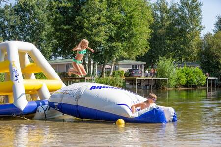 Kinder auf einem Spielplatz im See im Roompot Recreatiepark de Tolplas