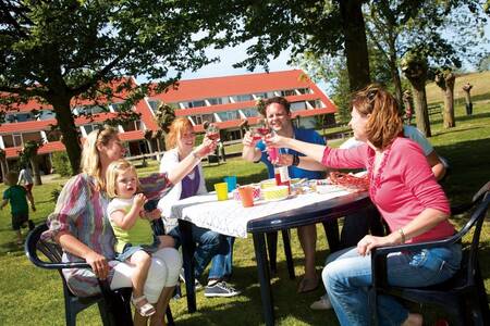 Familie auf einer Terrasse vor einem Apartmentkomplex im Roompot Ferienpark Aquadelta