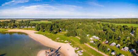 Luftaufnahme des Freizeitsees und der Ferienhäuser im Roompot Ferienpark Hunzedal