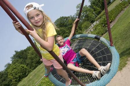 Kinder schaukeln auf dem Spielplatz im Ferienpark Roompot Ferienresort Bad Bentheim