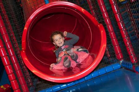 Kind auf einer Rutsche im Indoor-Spielplatz im Roompot Ferienresort Cochem