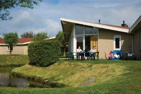 Familie auf der Terrasse eines Ferienhauses am Wasser im Ferienpark Roompot Hof Domburg