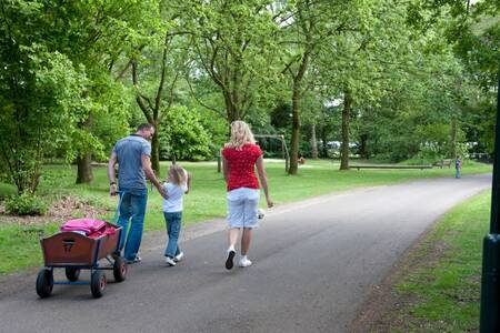 Familie mit Bollerwagen geht durch den Ferienpark Roompot Klein Vink