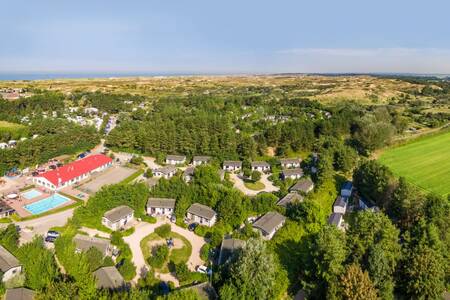 Luftaufnahme des Ferienparks Roompot Kustpark Egmond aan Zee mit der Nordsee am Horizont