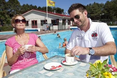 Menschen auf der Terrasse am Außenpool des Ferienparks Roompot Kustpark Egmond aan Zee