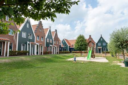 Kinder spielen auf einem Spielplatz zwischen den Ferienhäusern im Roompot Marinapark Volendam