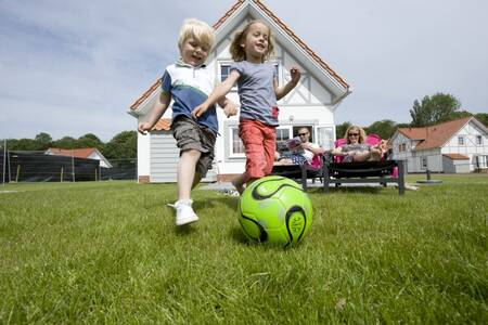 Kinder spielen im Garten eines Ferienhauses im Roompot Noordzee Résidence Cadzand-Bad