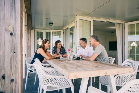 Menschen an einem Tisch in einem Ferienhaus im Ferienpark Roompot Noordzee Résidence Cadzand-Bad