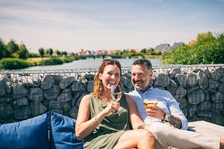 Mann und Frau genießen einen Drink auf der Terrasse der Roompot Noordzee Résidence Cadzand-Bad