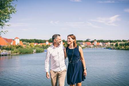 Mann und Frau vor dem See im Ferienpark Roompot Noordzee Résidence Cadzand-Bad