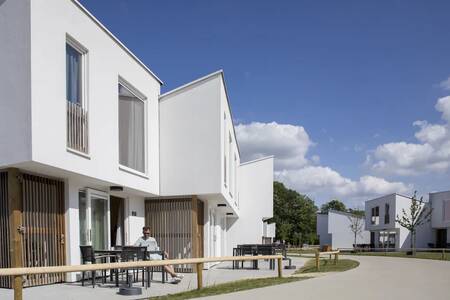 Ein Mann auf der Terrasse eines Ferienhauses im Ferienpark Roompot Park Eksel