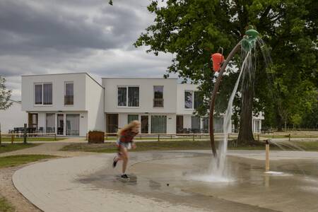 Kind spielt auf dem Wasserspielplatz im Ferienpark Roompot Park Eksel