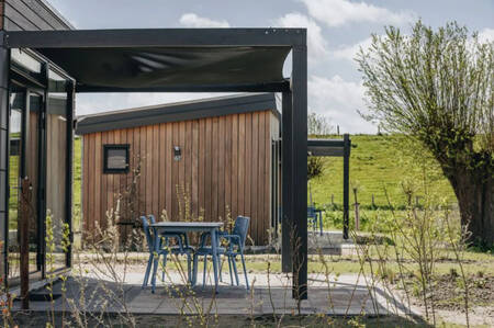 Terrasse mit Schattentuch eines Ferienhauses im Ferienpark Roompot Park Wijdenes