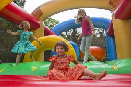 Kinder hüpfen auf der Hüpfburg im Ferienpark Roompot Plein Air des Chênes