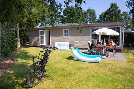 Menschen an einem Tisch im Garten eines Chalets im Ferienpark Roompot Recreatiepark de Tolplas