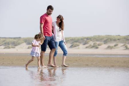 Menschen gehen am Strand in der Nähe von Ouddorp und Roompot Strandpark Duynhille spazieren