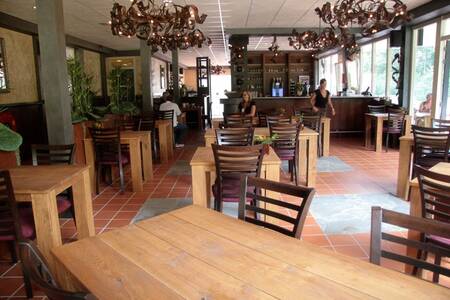Tische mit Stühlen im Restaurant im Roompot Ferienpark Herperduin