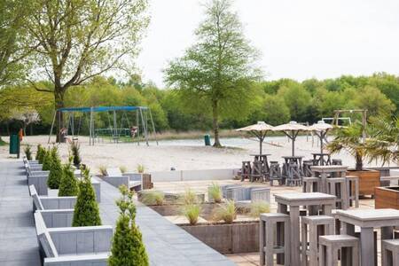 Terrasse und Spielplatz am Erholungssee neben dem Roompot Villaparc Schoonhovenseland