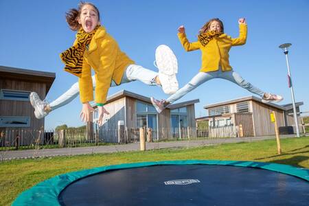 Kinder springen auf einem Trampolin in einem Ferienhaus im Ferienpark Roompot Water Village