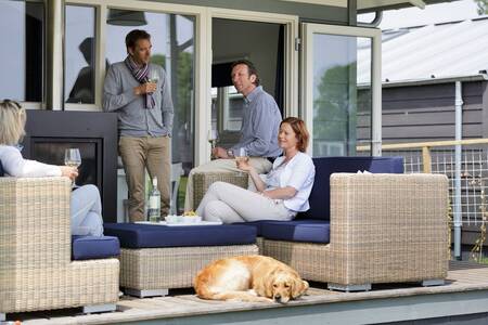 Menschen im Garten auf einer Lounge in einem Ferienhaus im Ferienpark Roompot Waterpark Terkaple