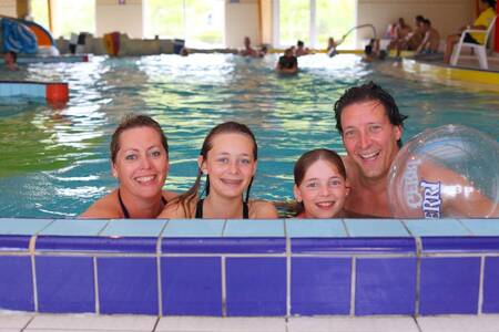 Die Familie schwimmt im Hallenbad des Ferienparks Roompot Zeebad