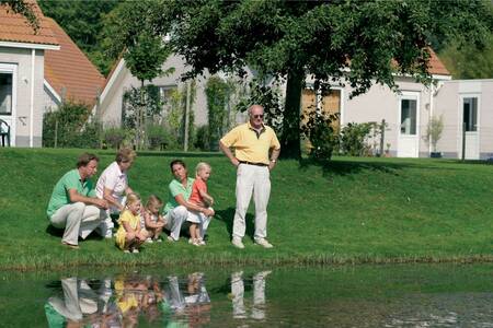 Leute, die im Ferienpark Roompot Zeeland Village mit Ferienhäusern hinter sich angeln