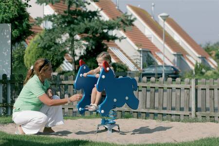 Mutter mit Kind auf dem Spielplatz im Ferienpark Roompot Zeeland Village