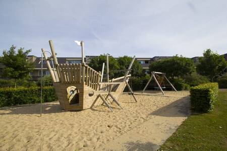 Spielgeräte und Schaukel auf einem Spielplatz in der Résidence Terschelling