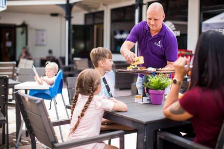 Familie beim Essen auf der Terrasse des Ferienparks Topparken Bospark Ede