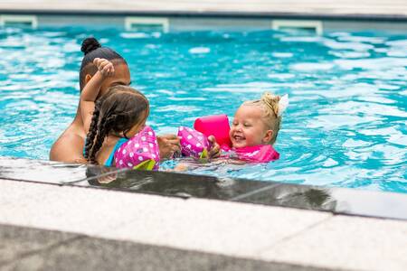 Familie schwimmen im Außenpool des Ferienparks Topparken Bospark Ede