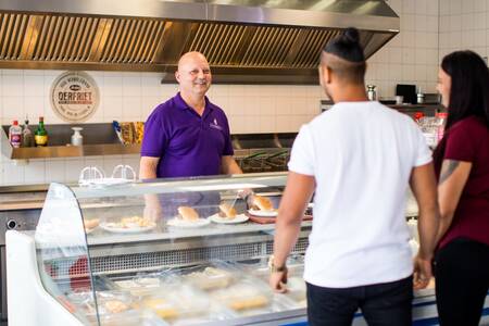 Die Leute bestellen Essen in der Snackbar des Ferienparks Topparken Bospark Ede