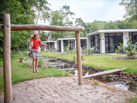 Mädchen auf einer Schaukel auf einem Spielplatz im Ferienpark Topparken Recreatiepark Beekbergen