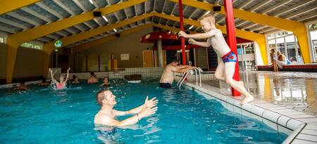 Menschen schwimmen im Hallenbad des Ferienparks Topparken Recreatiepark 't Gelloo
