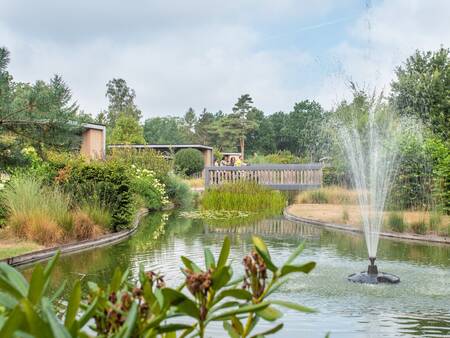 Brücke über einen Teich mit Springbrunnen im Ferienpark Topparken Landgoed de Scheleberg