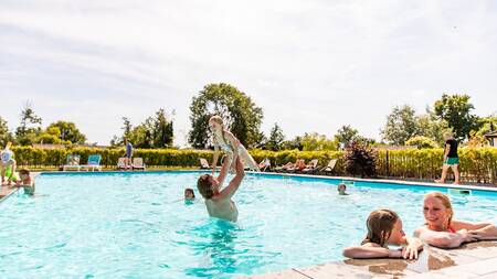 Menschen schwimmen im Außenpool des Ferienparks Topparken Parc de IJsselhoeve