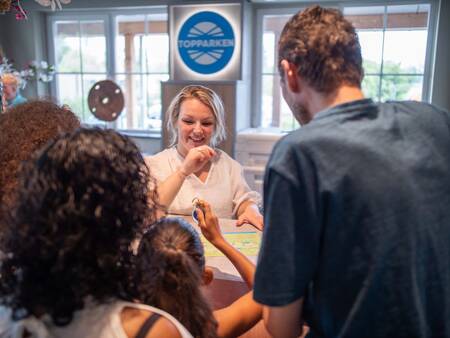 Die Familie erhält den Schlüssel an der Rezeption des Ferienparks Topparken Residence Lichtenvoorde