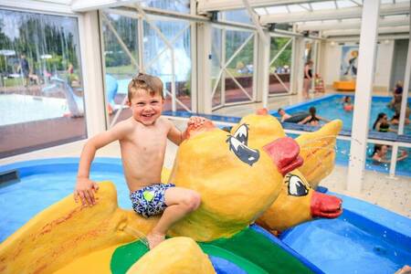 Kind auf Spielgeräten im Innenplanschbecken des Ferienparks Topparken Resort Veluwe